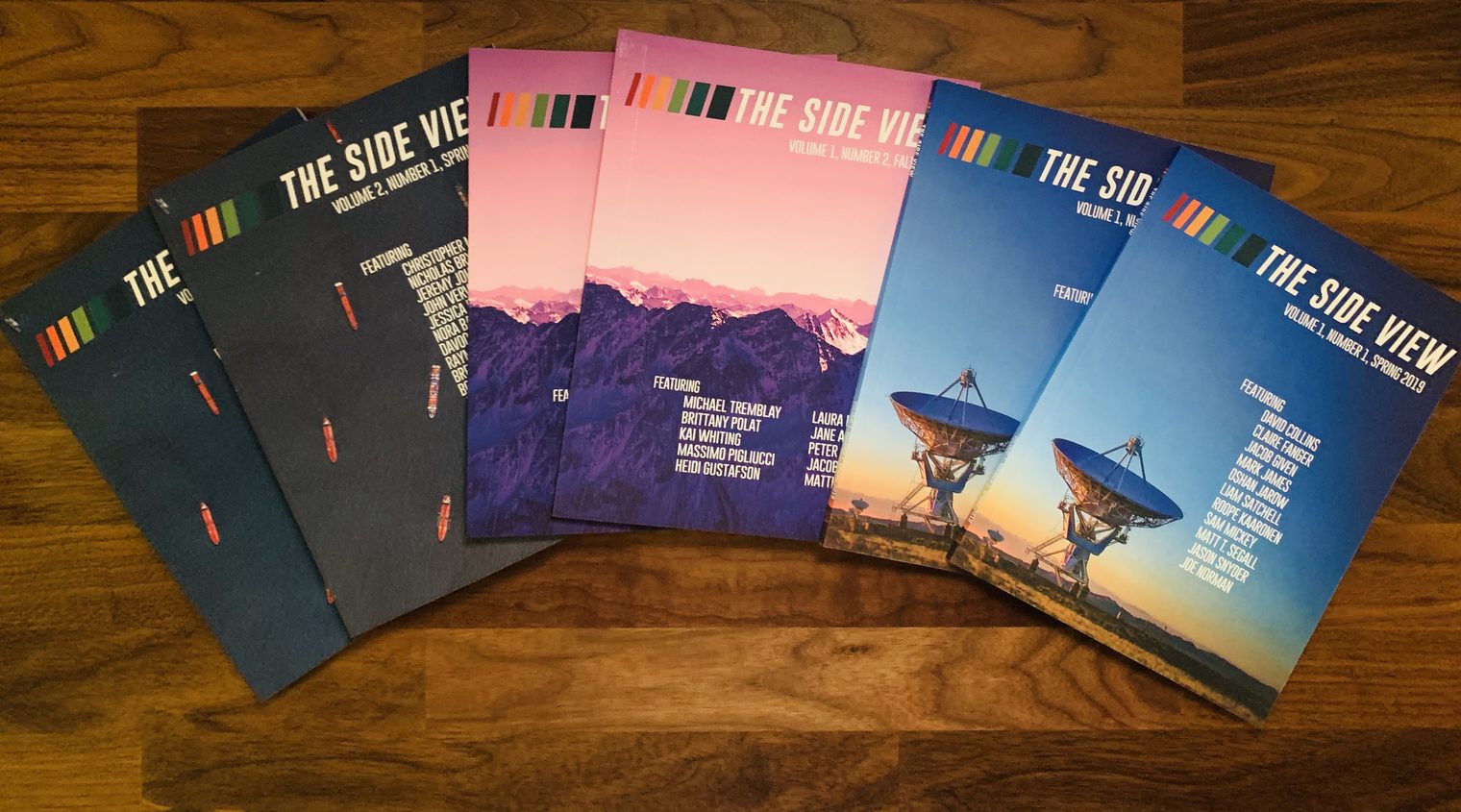 The six print copies of The Side View fanned on a desk: two copies each of Volume 1, Number 1 (Spring 2019), Volume 1, Number 2 (Fall 2019), and Volume 2, Number 1 (Spring 2020).